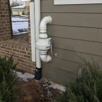 radon system installed in a house exterior beneath a window