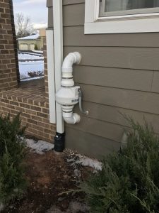 radon system installed in a house exterior beneath a window